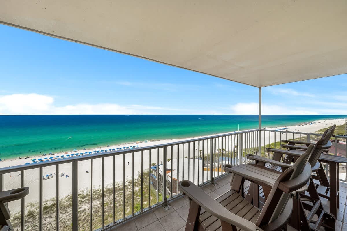 The Summit 1001 – Balcony view of the beach, ocean, and sky with outdoor seating.