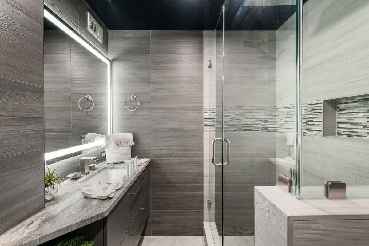 The Summit 1001 – Modern bathroom with double vanity, glass shower, and neutral tile finishes.