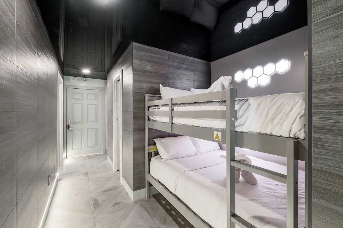 The Summit 1001 – Bunk bed setup in a narrow hallway with gray wood paneling and modern lighting.