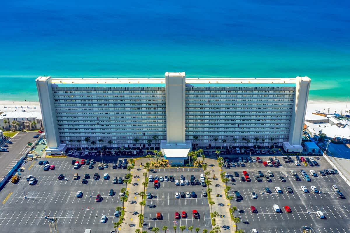 The Summit 1502 – Five-story beachfront building with adjacent parking lot and ocean view.
