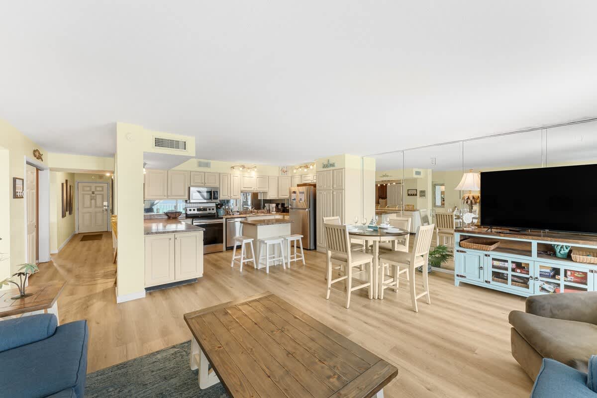The Summit 1502 – Spacious living area with kitchen, dining table, and large TV in a modern vacation rental.