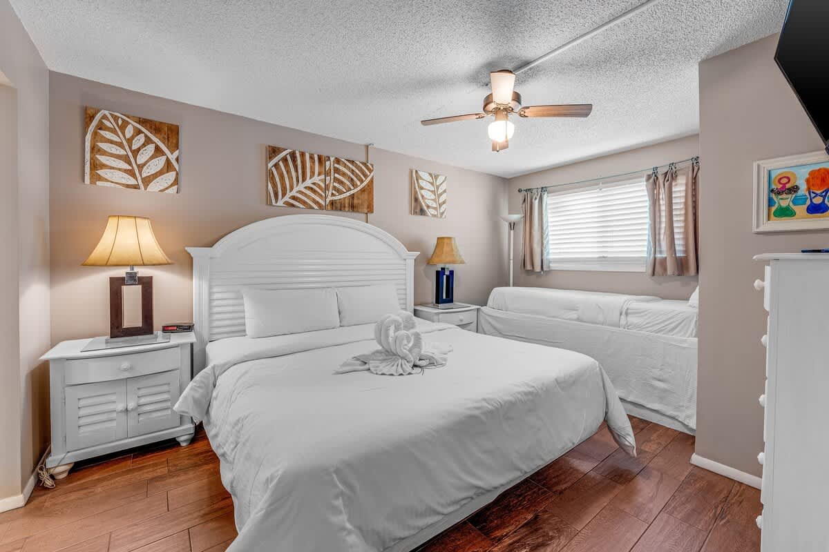 The Summit 828 – Cozy bedroom with a queen bed, decorative art, window, and a daybed.