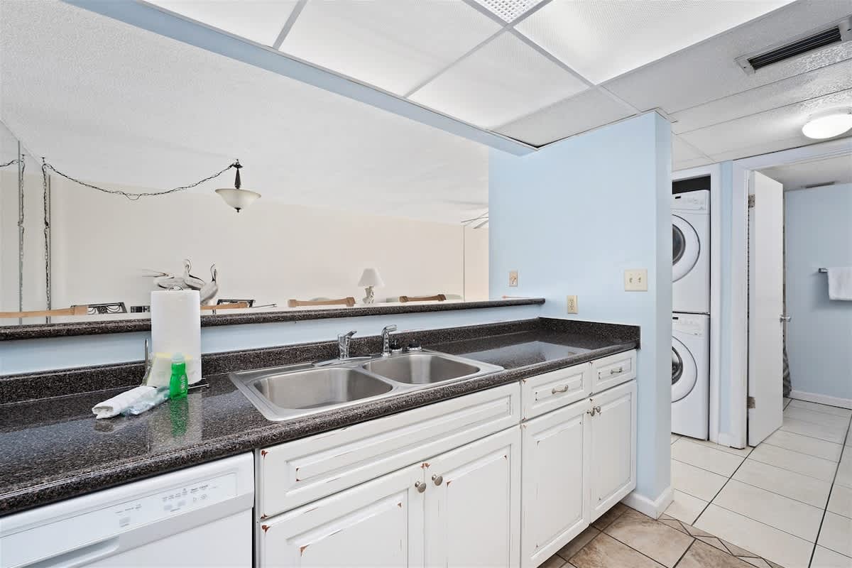 Moondrifter 606 – Kitchen area with stainless steel sink, granite countertops, and laundry machines visible in the background.