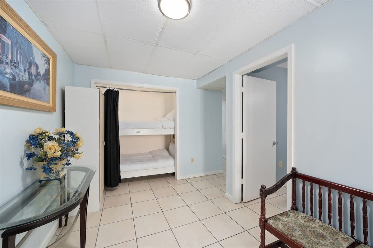 Moondrifter 606 – Bunk beds in a light blue room with tile floor and a small table.