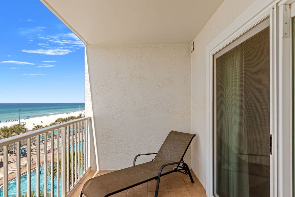 The Summit 524 – Balcony view with a lounge chair overlooking the beach and ocean.