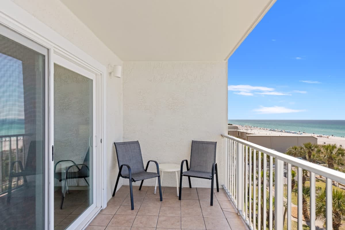 The Summit 524 – Balcony with two chairs and a table, ocean view and beach in the distance.