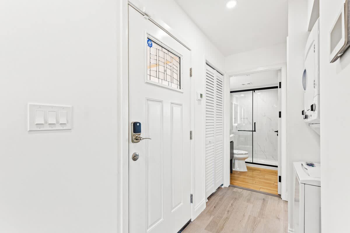 Ocean Breeze 2C – Entryway with white walls, door, bathroom doorway visible, and laundry area on the right.