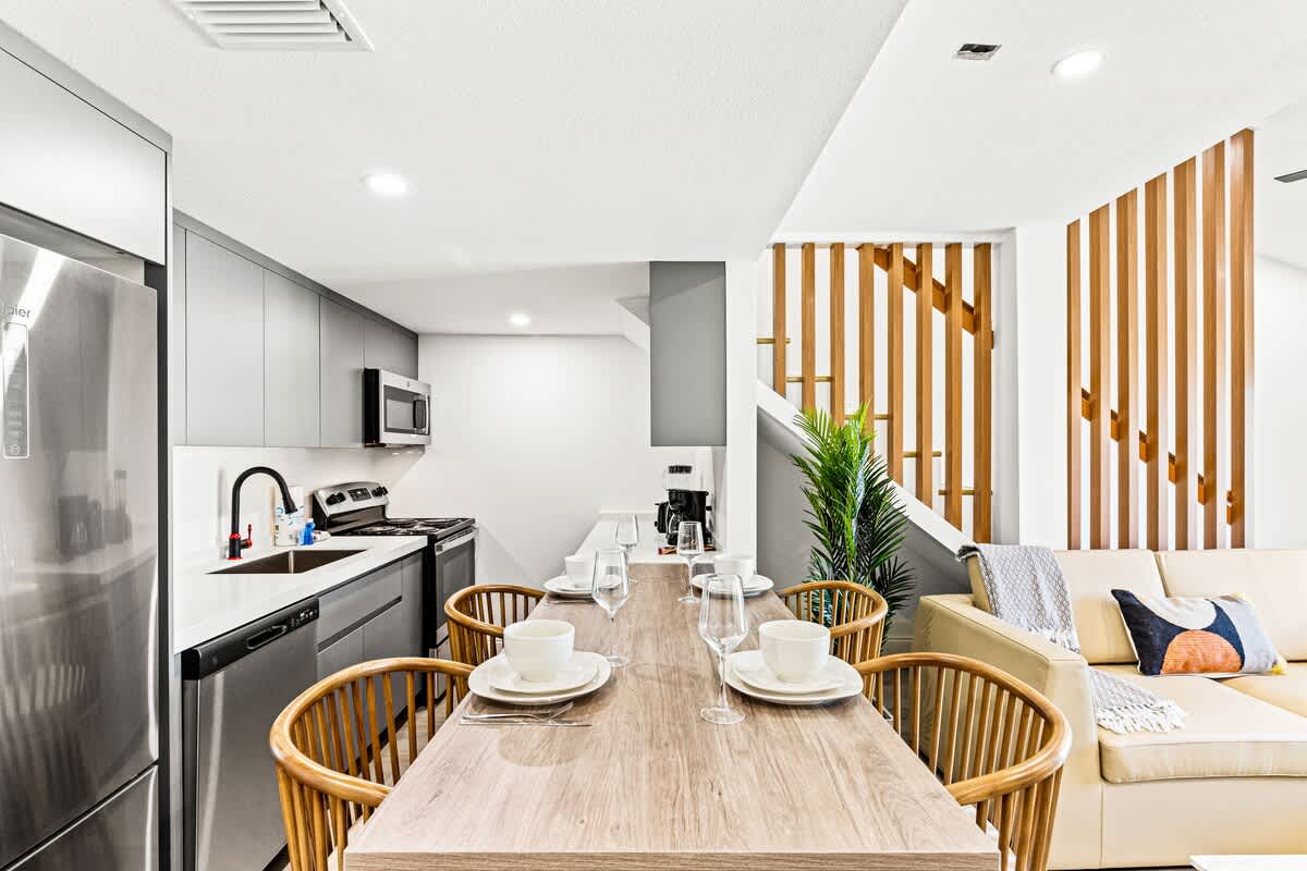 Ocean Breeze 2C – Open kitchen and dining area with a staircase, featuring modern appliances and a cozy seating area.