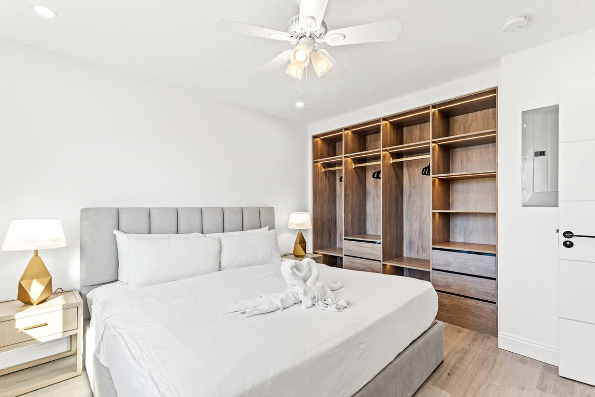 Ocean Breeze 2C – Bedroom with a king-size bed, bedside lamps, and a built-in wardrobe.