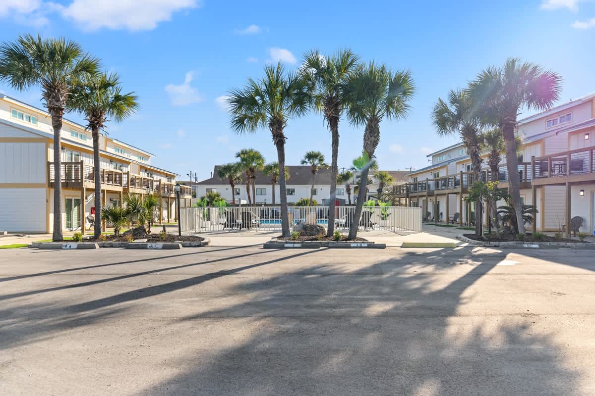 Ocean Breeze 2C – Exterior view of Ocean Breeze 2C with palm trees and pool area in front of the rental units.