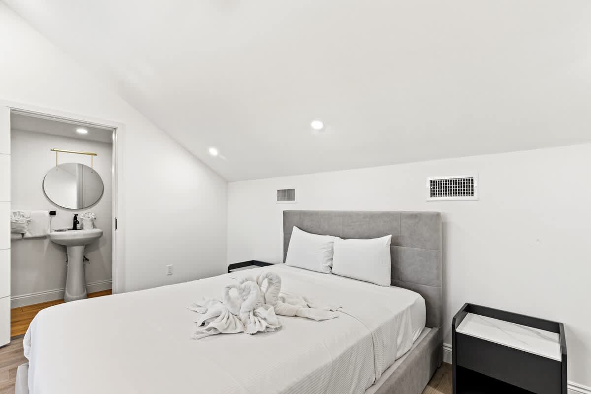 Ocean Breeze 2C – Cozy bedroom with a queen bed, en-suite bathroom, and modern decor.