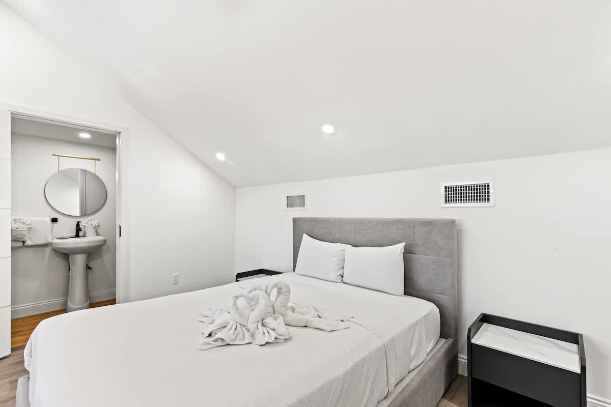 Ocean Breeze 3C – Cozy bedroom with a queen bed, en-suite bathroom, and decorative towel arrangement.