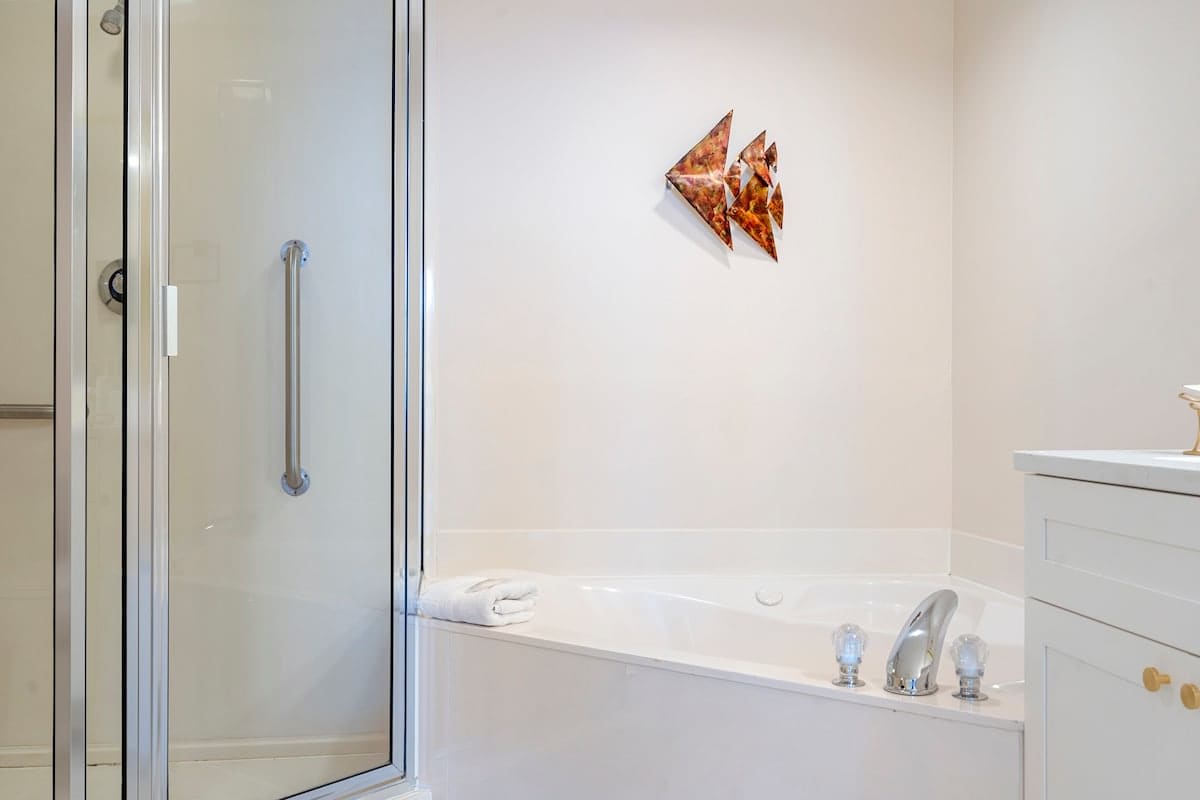 Majestic T2 - 1606 – Bathroom featuring a glass shower, a jacuzzi tub, and modern fixtures.