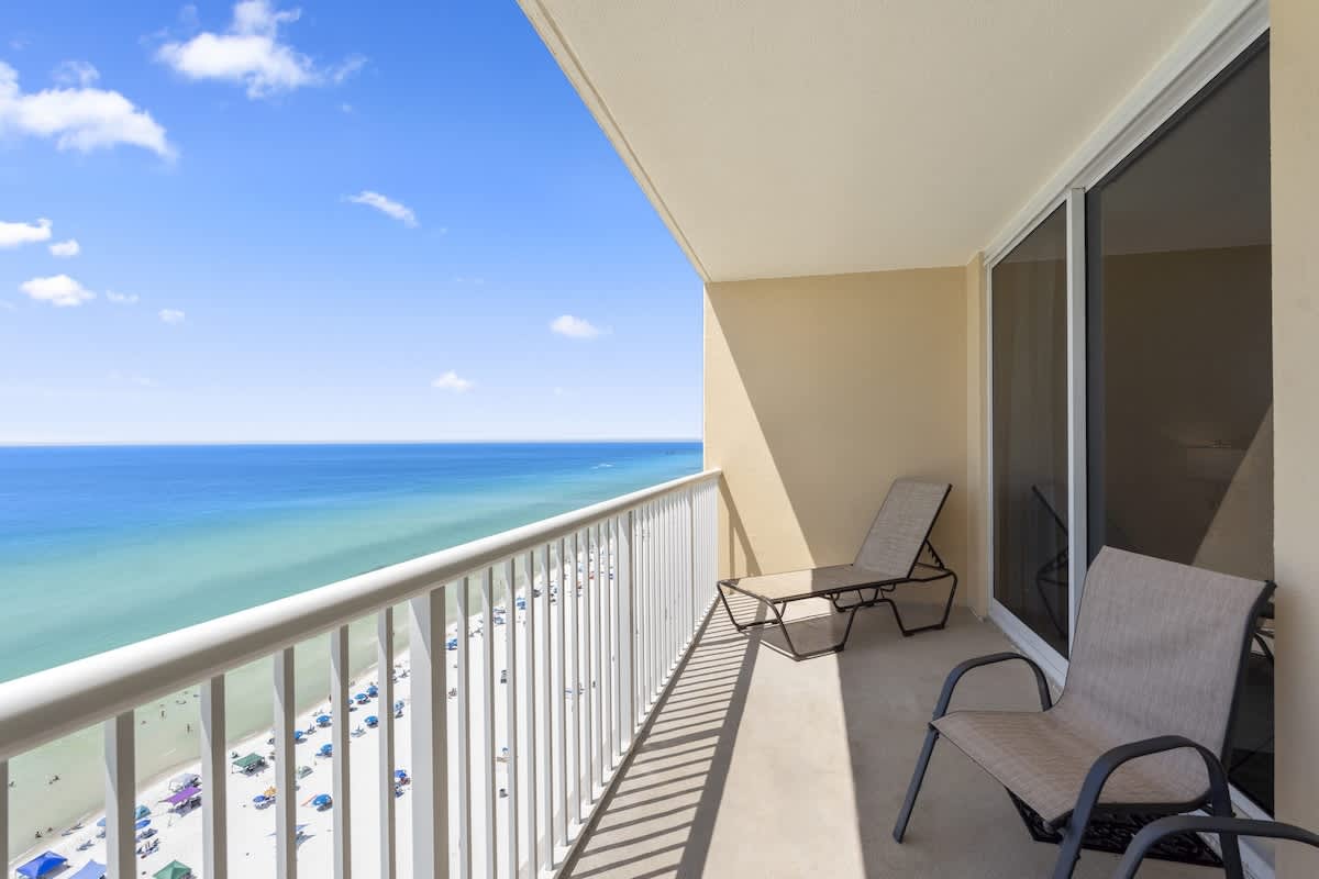 Majestic T2 - 1606 – Balcony with two lounge chairs overlooking a beach and ocean view.