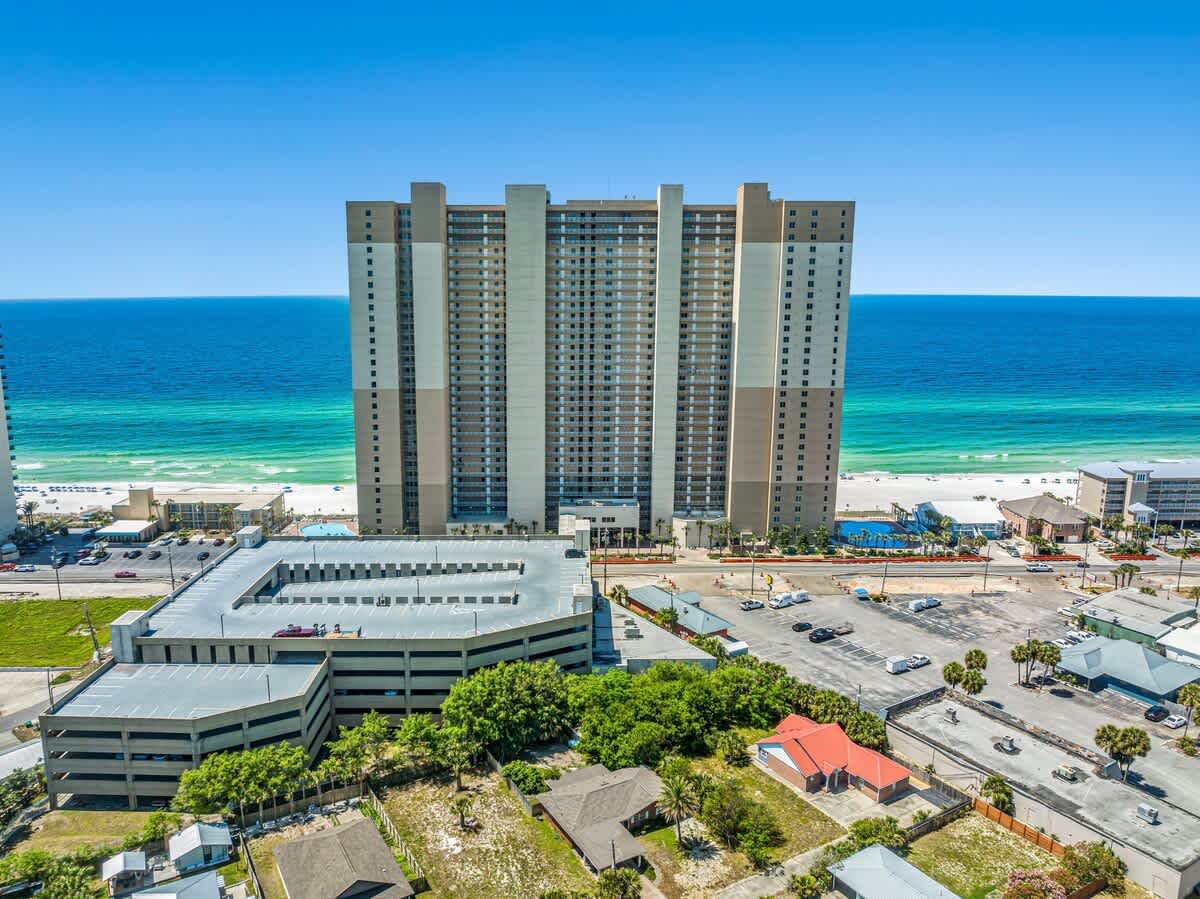 Tidewater 2615 – Aerial view of Tidewater 2615 condominium with ocean and beach in the background, parking area in the foreground.