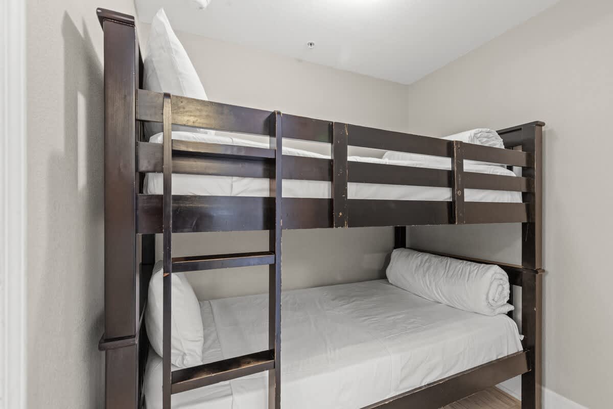 Tidewater 2615 – Bunk beds in a small bedroom with neutral walls and white bedding.