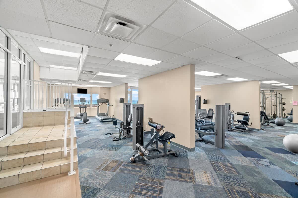 Tidewater 2615 – Modern gym with exercise equipment, large windows, and a view of the outdoors.