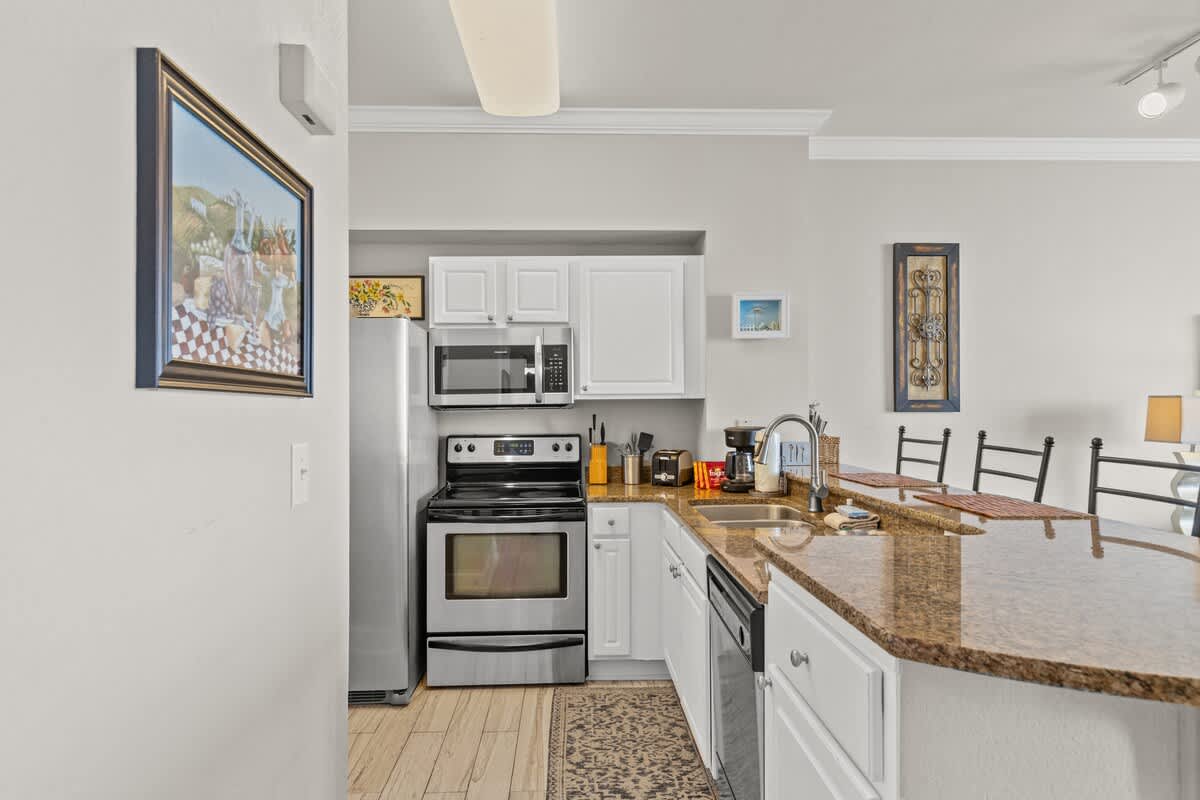 Tidewater 2615 – Modern kitchen with stainless steel appliances, granite countertops, and decorative wall art.