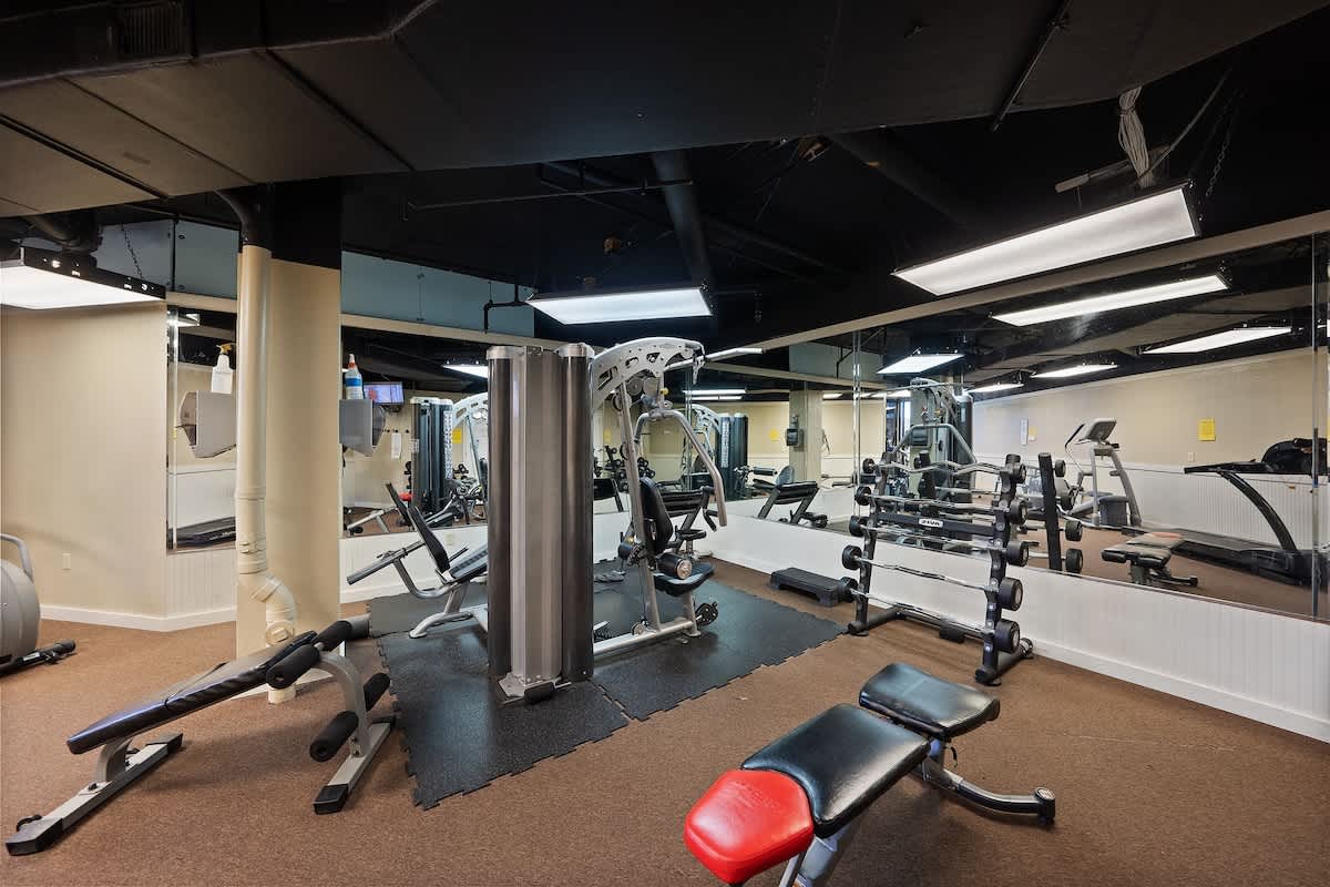 Dunes C605 – Fitness room with various exercise equipment, mirrors, and rubber flooring.
