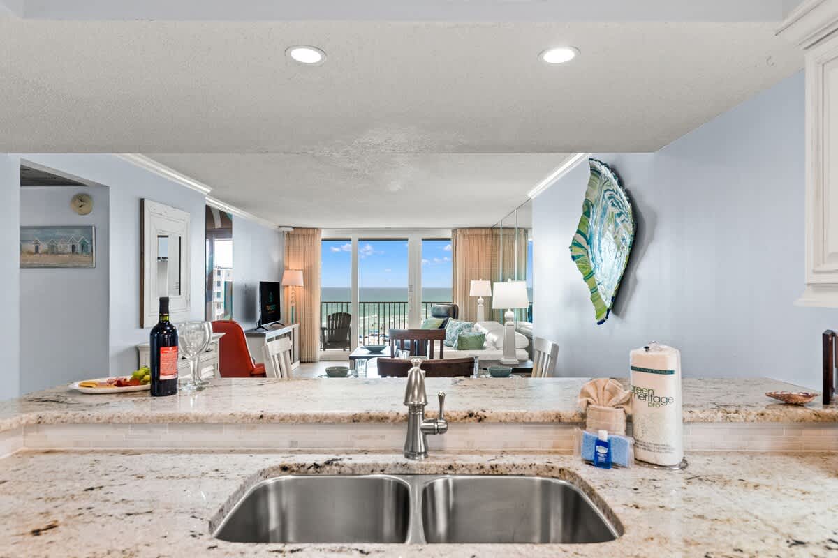 Dunes C605 – Spacious living area with ocean view, granite countertops, and casual seating.