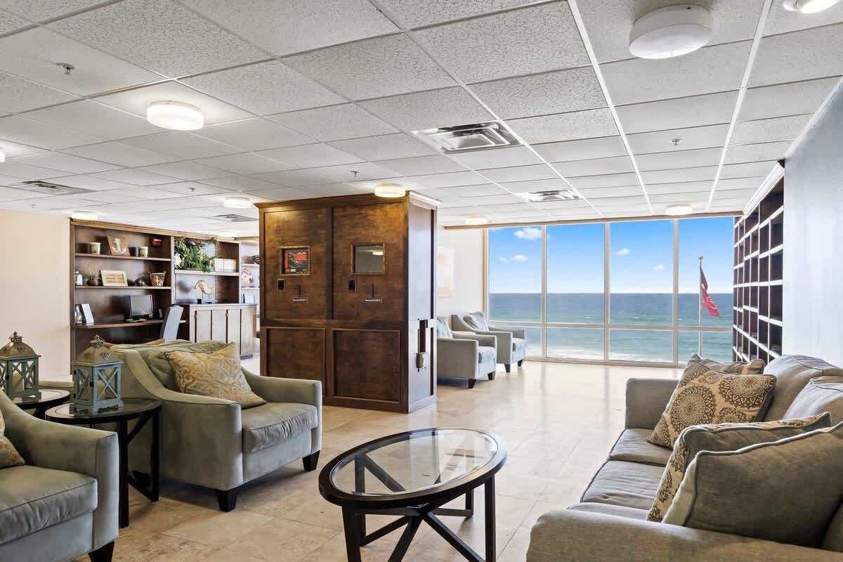 Tidewater 200 – Open lounge area with ocean views, comfortable seating, and a wooden bookshelf.