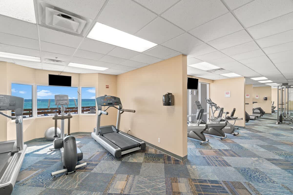 Tidewater 200 – Fitness room with exercise equipment and ocean view from large windows.