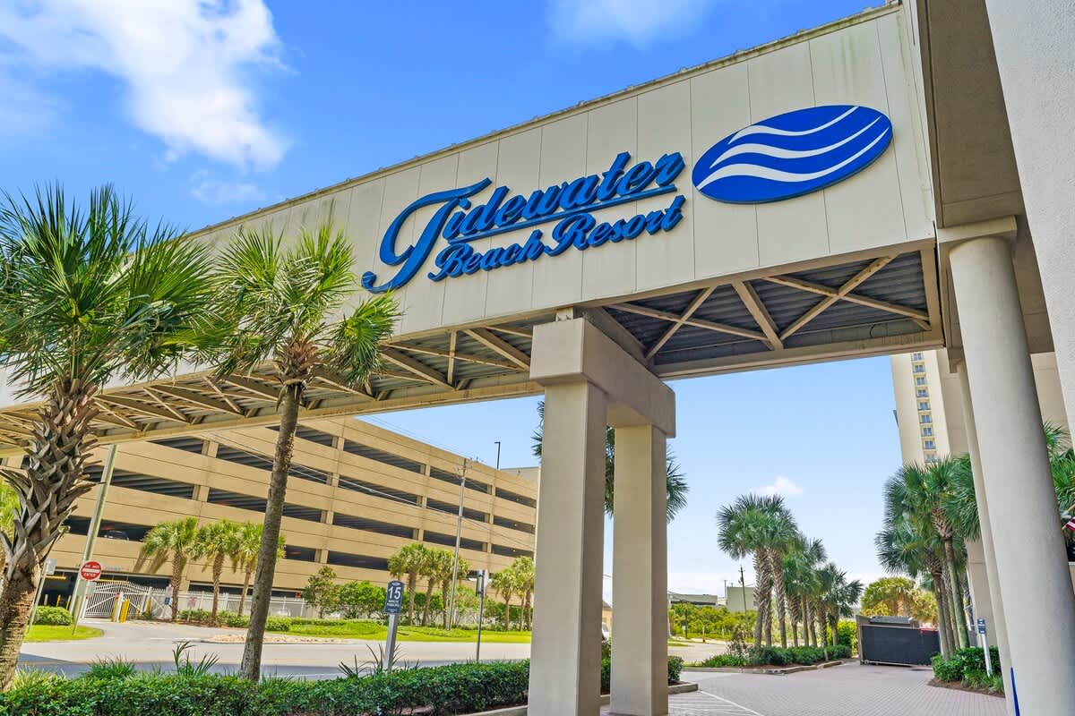 Tidewater 200 – Tidewater Beach Resort entrance with palm trees and a clear blue sky in the background.
