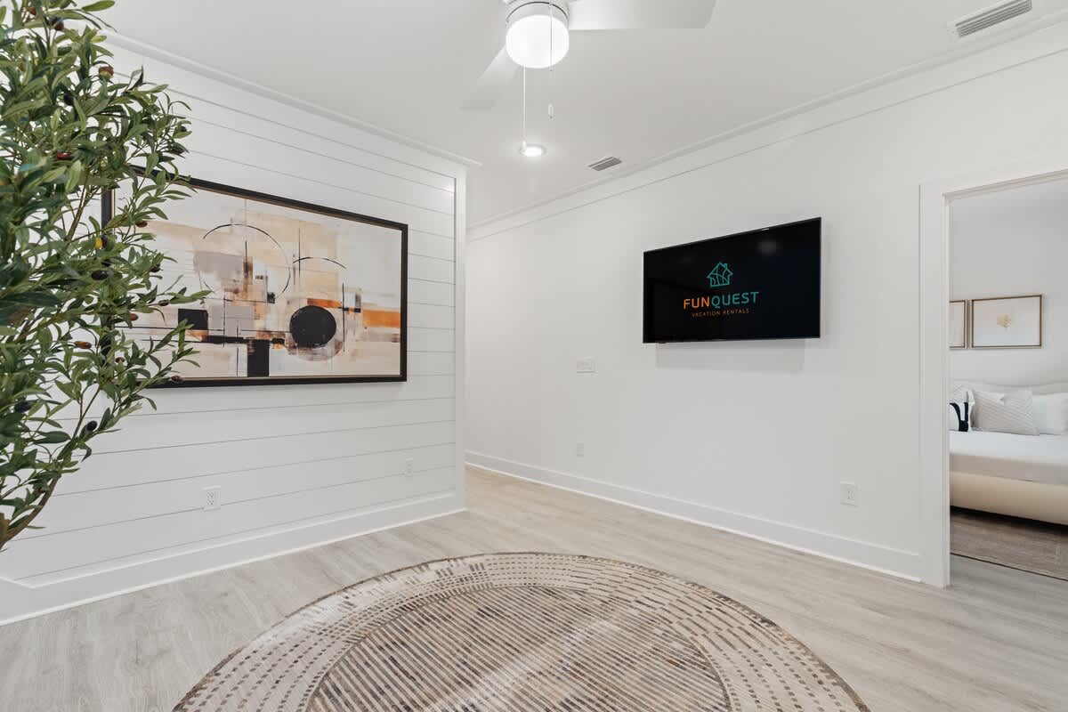 224 W Willow Mist Rd – Living room with wall art, TV, ceiling fan, and visible bedroom entrance.