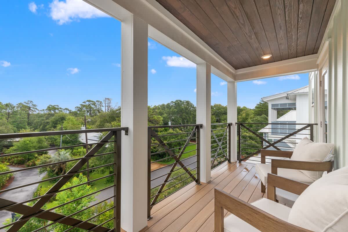 224 W Willow Mist Rd – Covered balcony with wooden railing and seating, overlooking greenery and a nearby road.