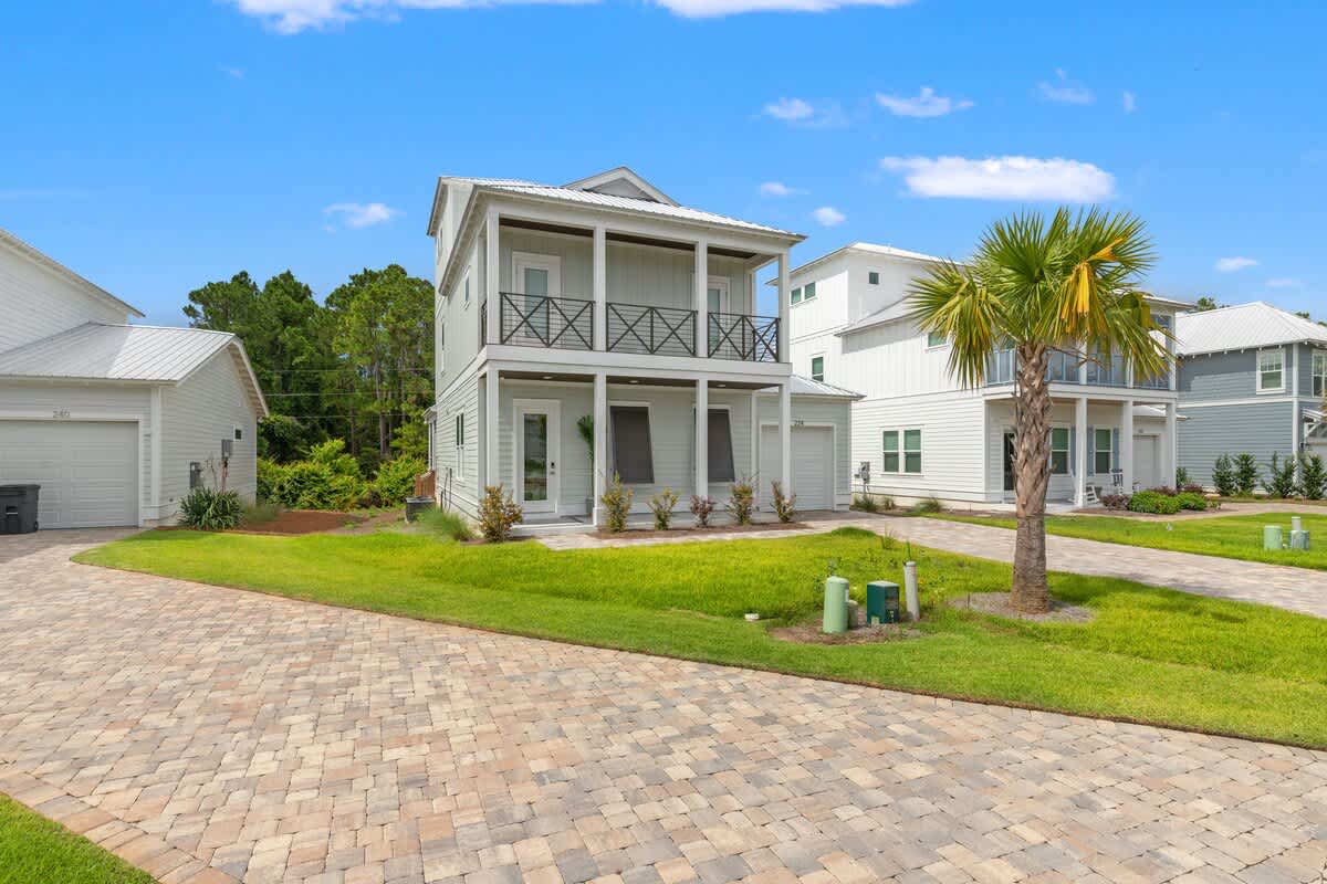 224 W Willow Mist Rd – Two-story house with a front porch, palm tree, and landscaped yard on a brick-paved driveway.