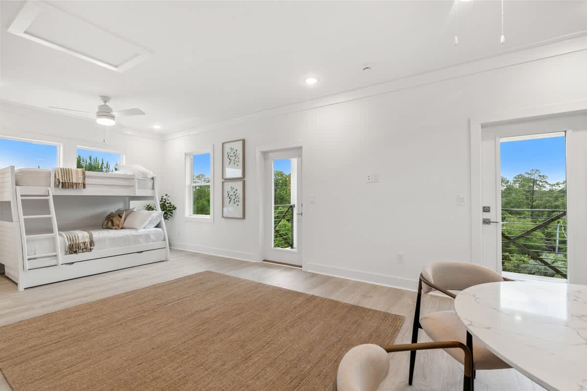 224 W Willow Mist Rd – Bright bedroom featuring a bunk bed, large windows, and a door leading to a balcony with greenery views.