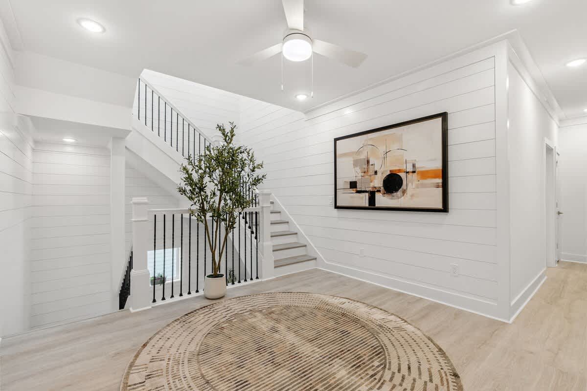 224 W Willow Mist Rd – Bright entryway with staircase, potted plant, circular rug, and abstract wall art.