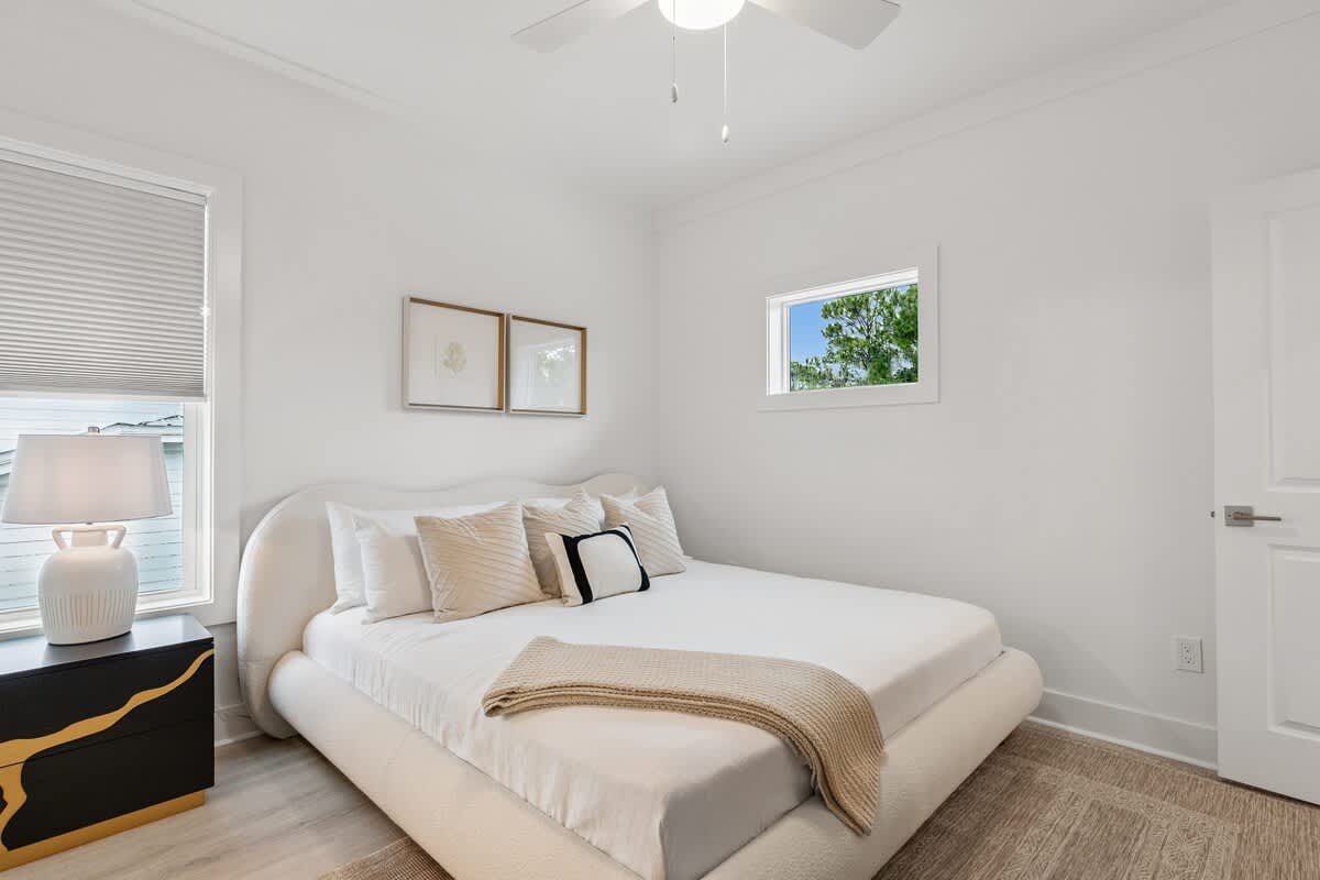 224 W Willow Mist Rd – Cozy bedroom with a large bed, decorative pillows, lamp, and window showcasing greenery outside.