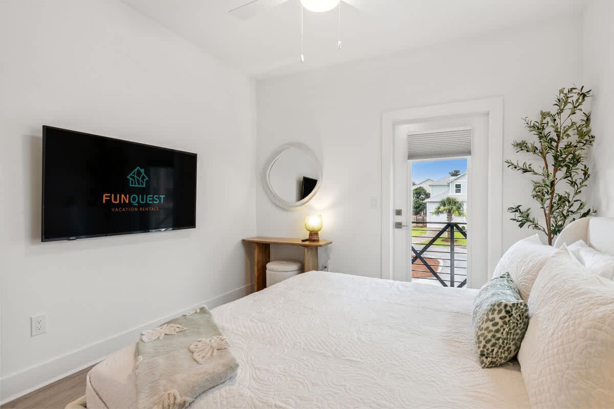 224 W Willow Mist Rd – Bright bedroom with a queen bed, TV, and door leading to an outdoor view.