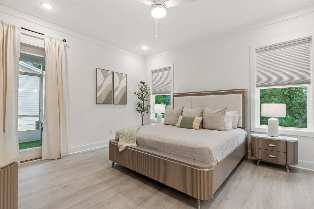 224 W Willow Mist Rd – Modern bedroom with a bed, nightstand, plants, and window facing greenery.
