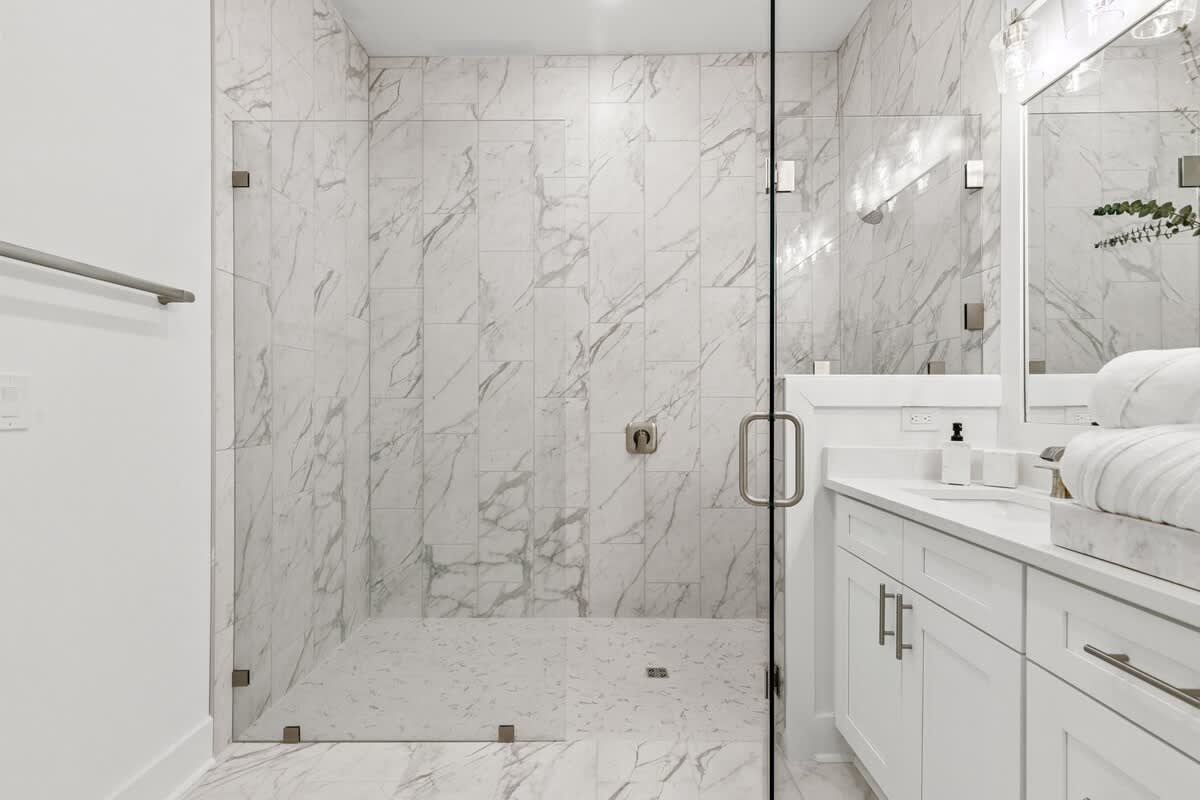 224 W Willow Mist Rd – Modern bathroom with marble tiles, walk-in shower, and dual sink vanity.