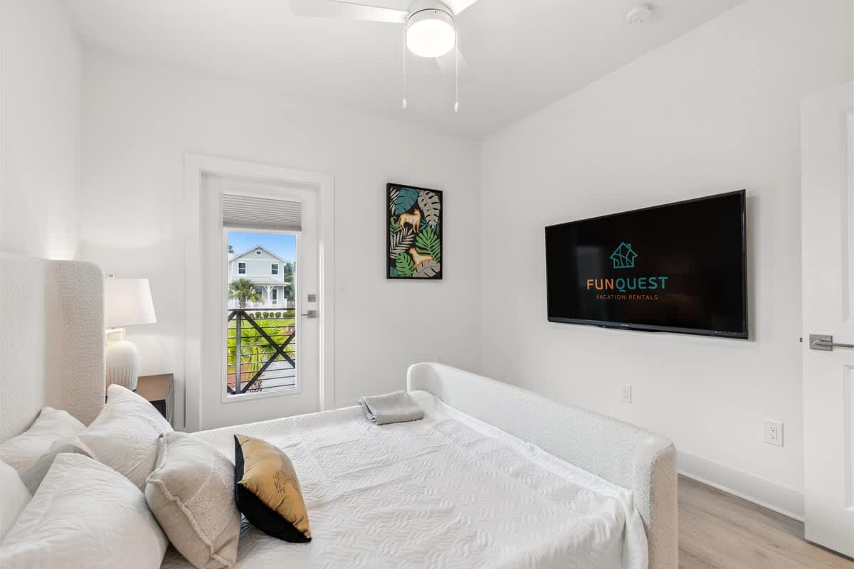 224 W Willow Mist Rd – Bright bedroom featuring a queen bed, wall-mounted TV, and sliding door to an outdoor view.