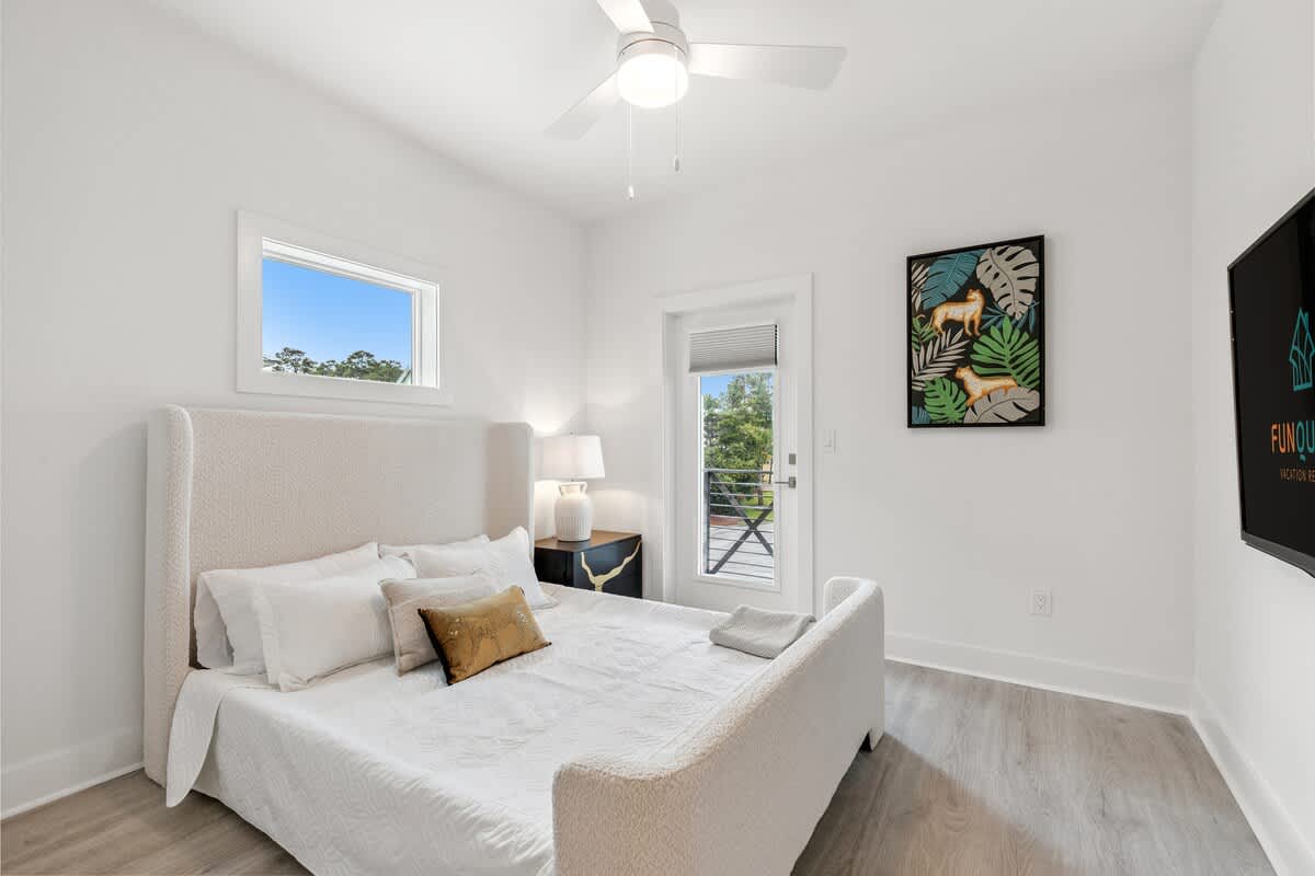224 W Willow Mist Rd – Bright bedroom with a queen bed, nightstand, lamp, and door to a balcony view.