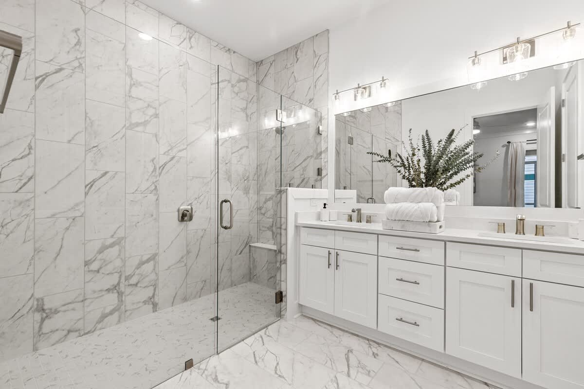 224 W Willow Mist Rd – Modern bathroom with marble walls, glass shower, double sink vanity, and towel storage.
