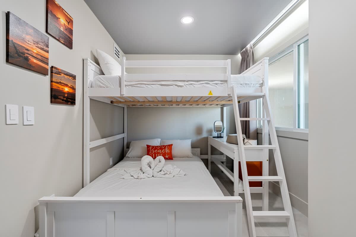 The Summit Penthouse 1501 – Bunk bed with a double bed below, beach-themed decor, and a desk with a lamp in a well-lit room.