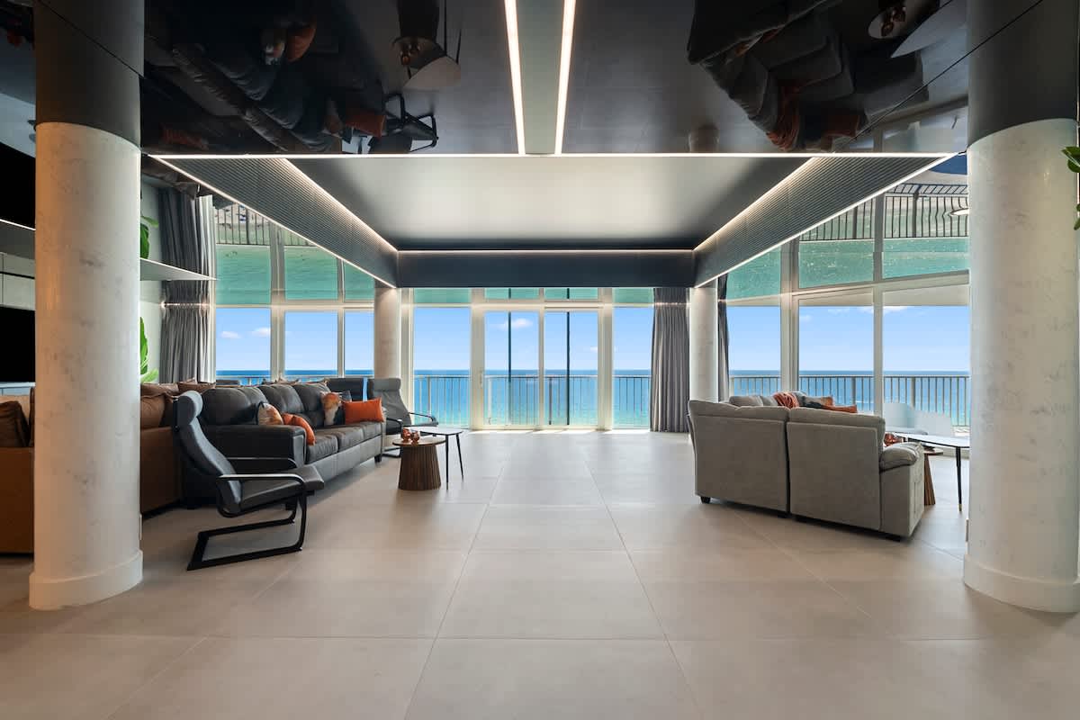 The Summit Penthouse 1501 – Open living room with ocean view, modern furnishings, and large windows.