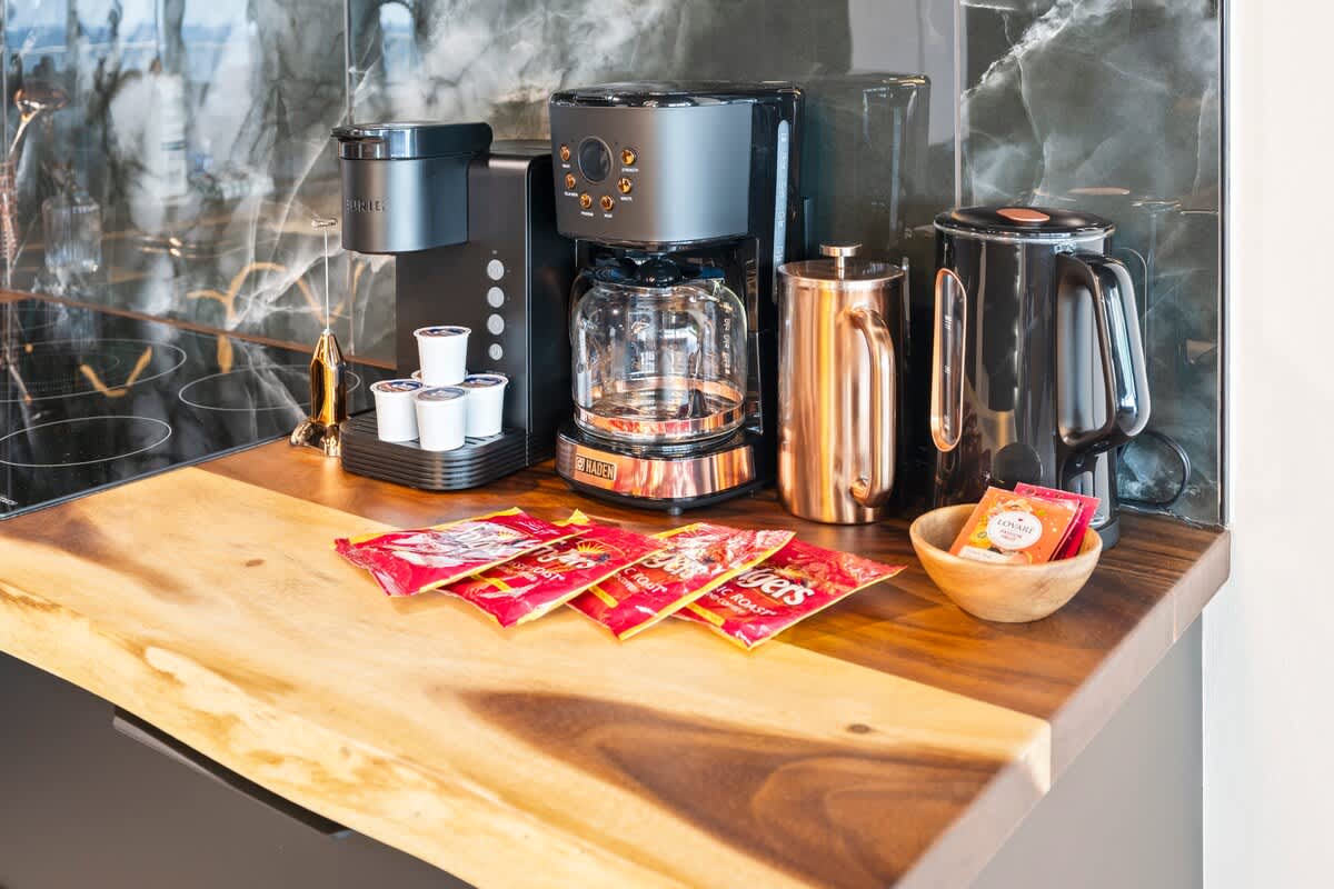 The Summit Penthouse 1501 – Coffee maker, kettle, and tea bags on a wooden countertop in a modern kitchen.