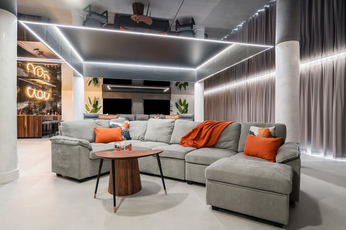 The Summit Penthouse 1501 – Spacious living area with a large gray sectional sofa, wooden coffee table, and modern decor.