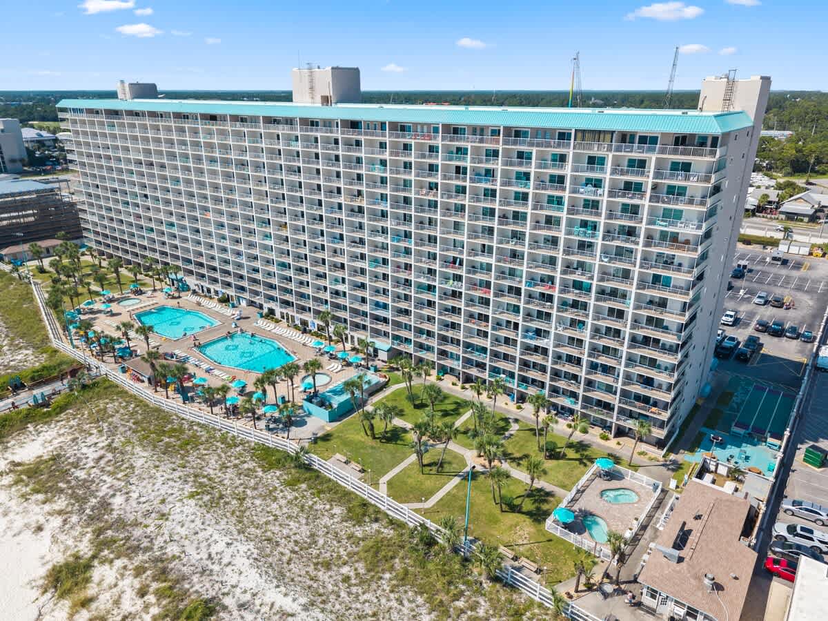 The Summit Penthouse 1501 – Aerial view of The Summit Penthouse 1501, featuring pools, palm trees, and surrounding beachfront area.