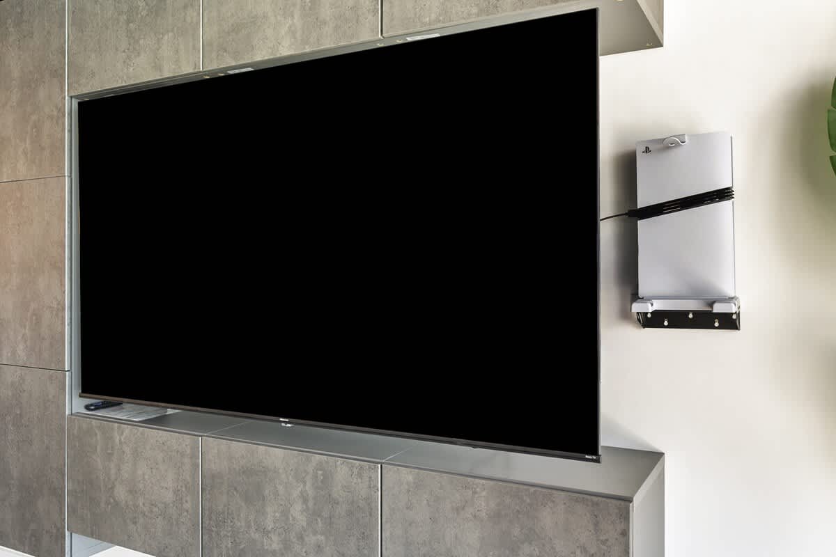 The Summit Penthouse 1501 – Living room with a large flat-screen TV mounted on a modern gray cabinet.