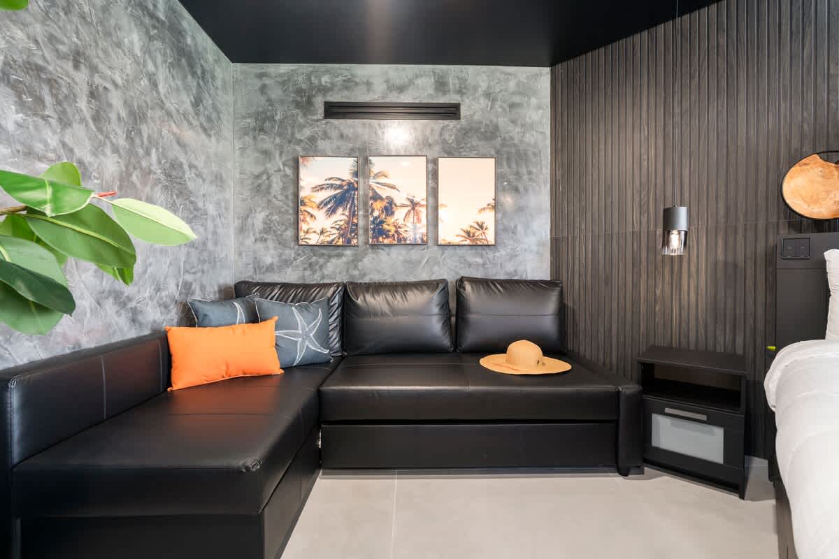 The Summit Penthouse 1501 – Modern living area with black sectional sofa, decorative pillows, wall art, and plant accents.