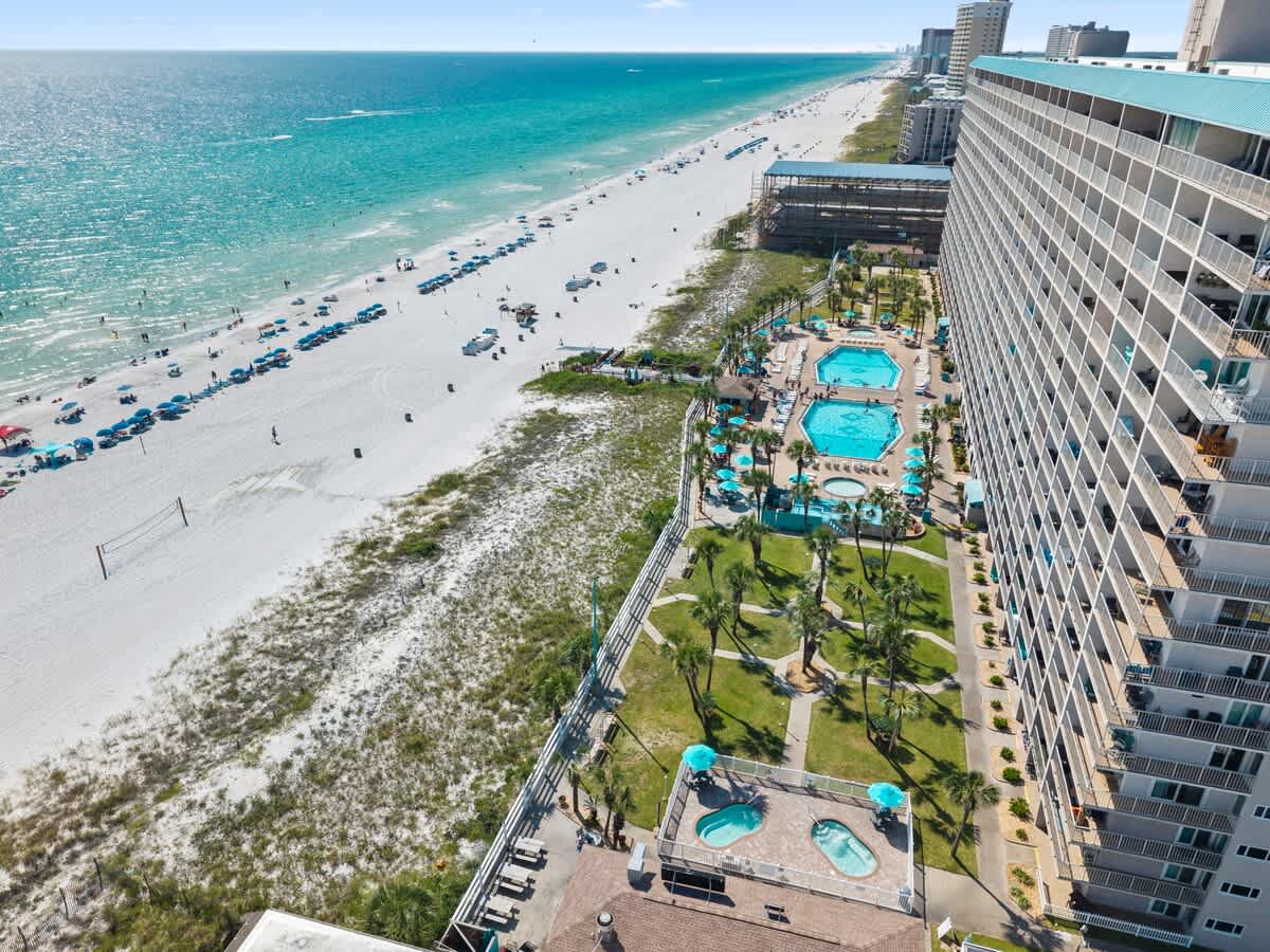 The Summit Penthouse 1501 – Aerial view of beach, pools, and garden area outside The Summit Penthouse 1501 with ocean in background.