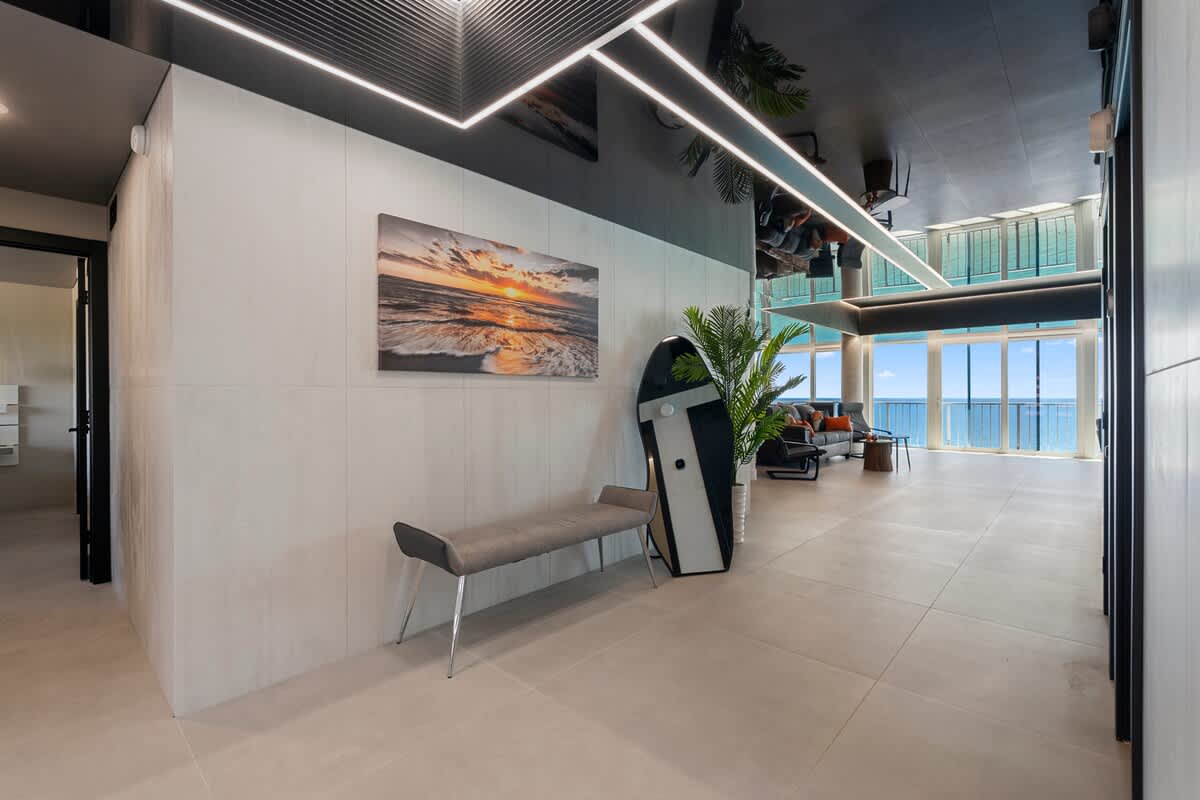 The Summit Penthouse 1501 – Modern penthouse living area with ocean views, seating area, and beach-themed decor.