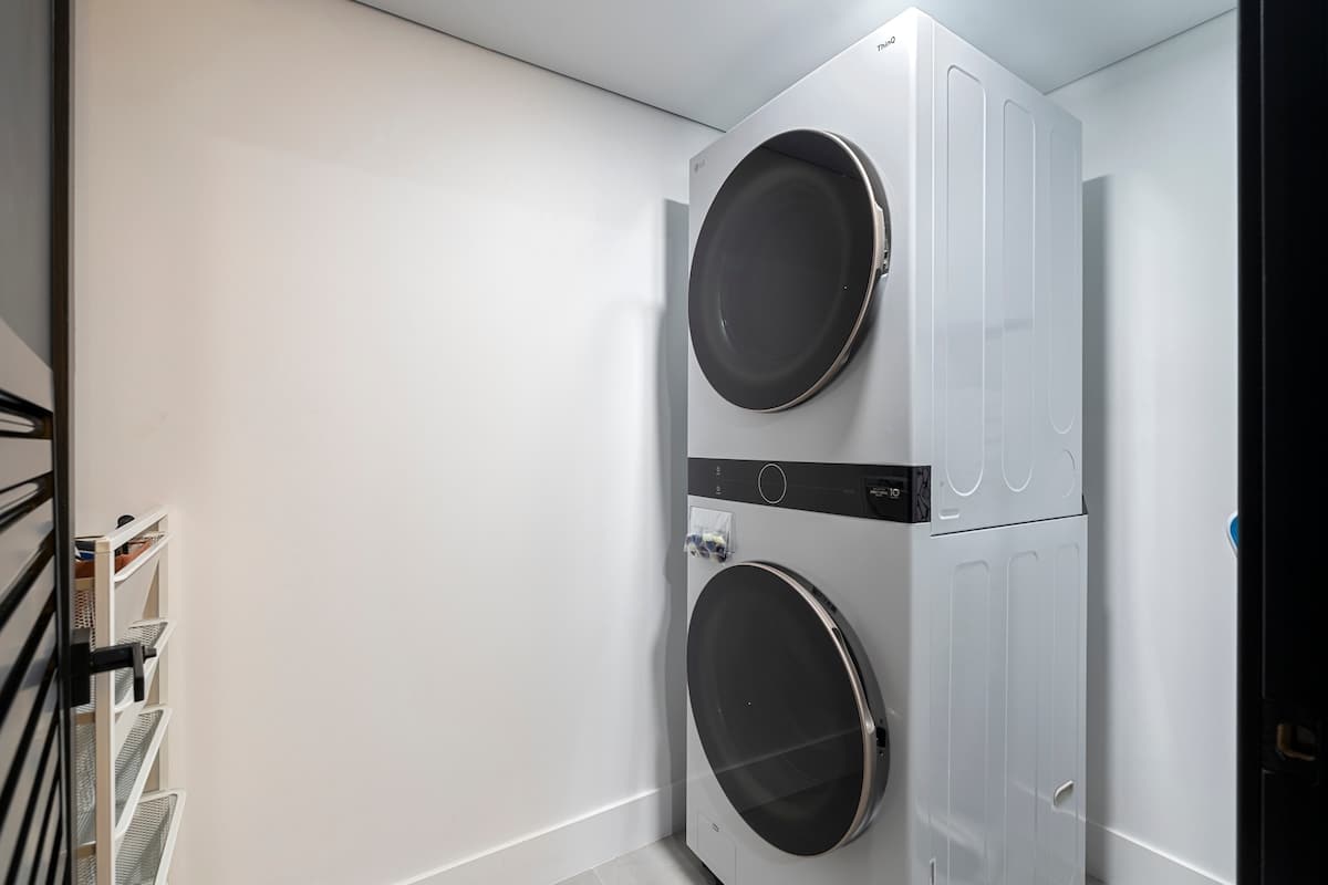 The Summit Penthouse 1501 – Laundry room featuring stacked washer and dryer against a plain white wall.
