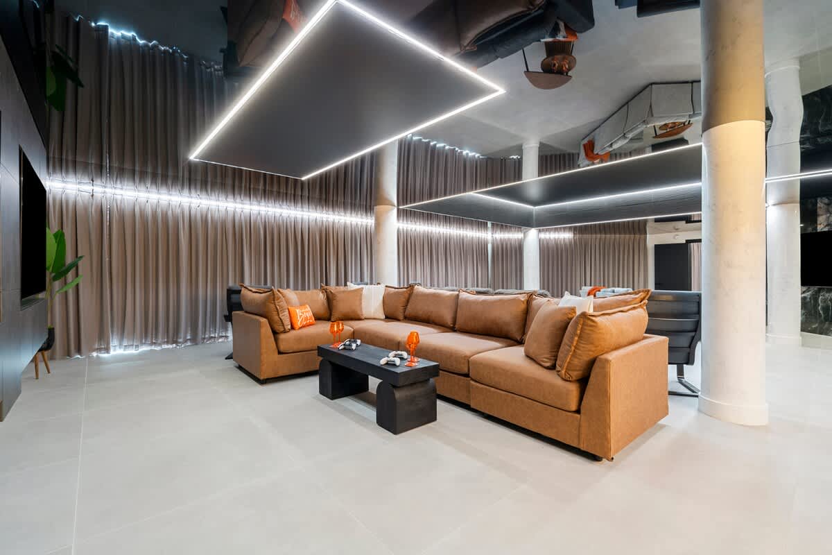 The Summit Penthouse 1501 – Spacious living area with a large sectional sofa, a coffee table, and decorative lighting.